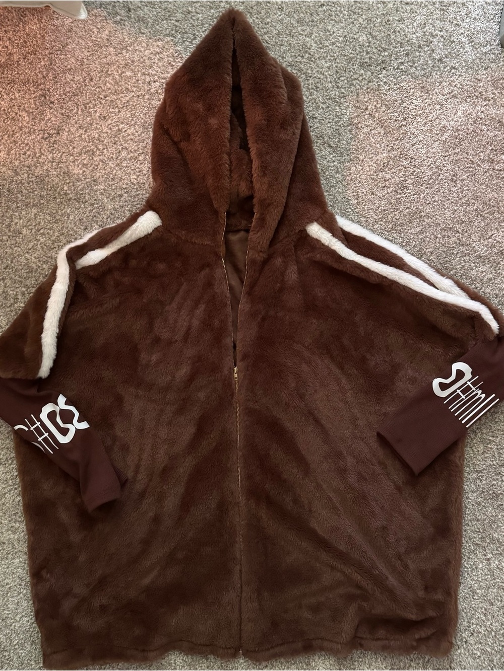 Brown, oversized, hooded zip jacket. white striped down shoulder. Gold zipper.